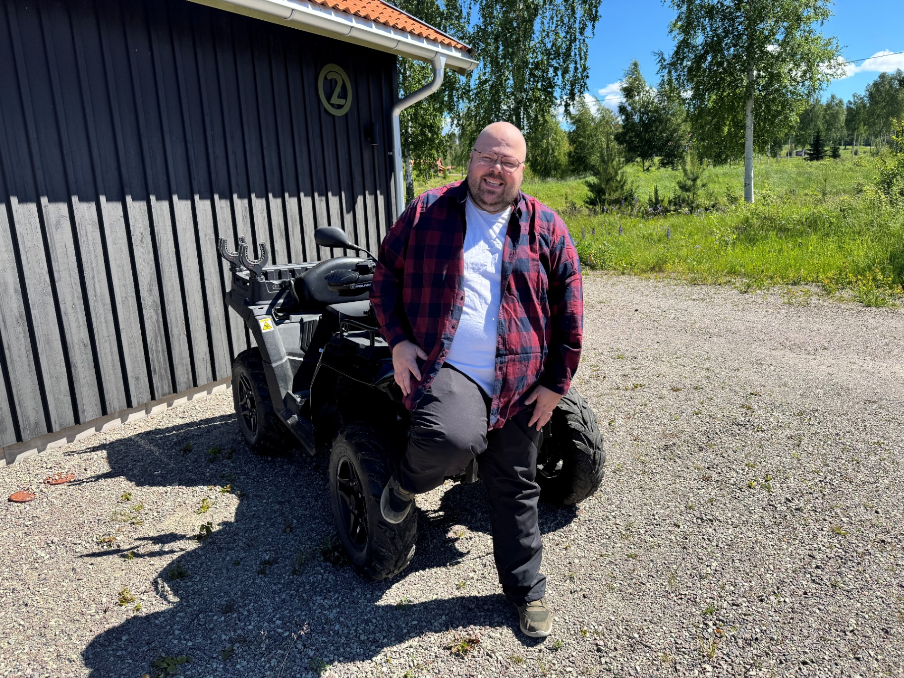 Klippar Robin vid sin EGO åkgräsklippare framför verkstaden